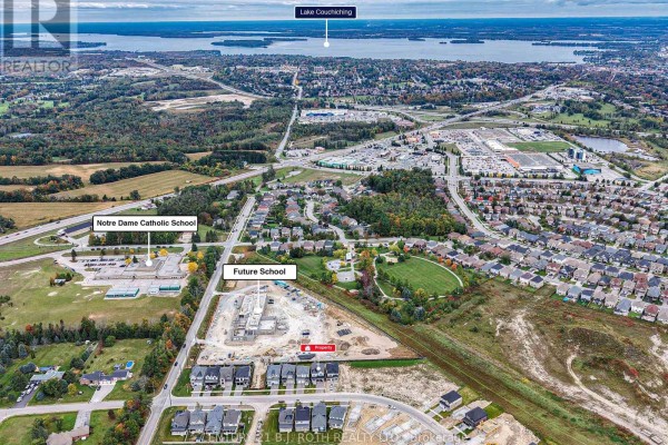 Aerial view showing the property's location near Notre Dame Catholic School and future school construction. - 3183 Orion Boulevard, Orillia