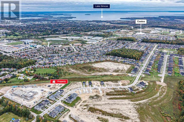Aerial view of the property and surrounding subdivision, with Lake Simcoe visible in the distance. - 3183 Orion Boulevard, Orillia