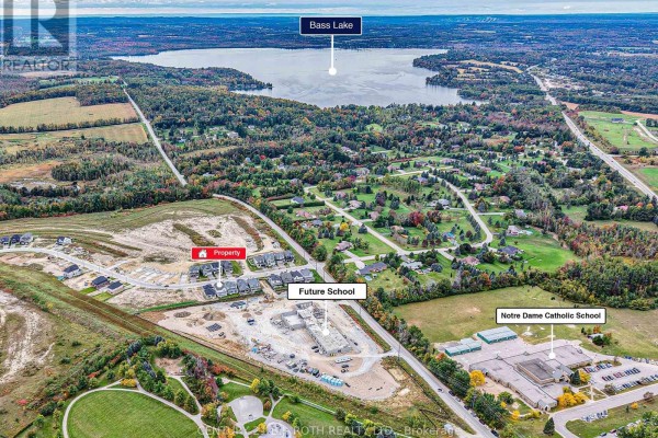 Aerial view of the property and surrounding subdivision, showing Bass Lake and the future school site. - 3183 Orion Boulevard, Orillia