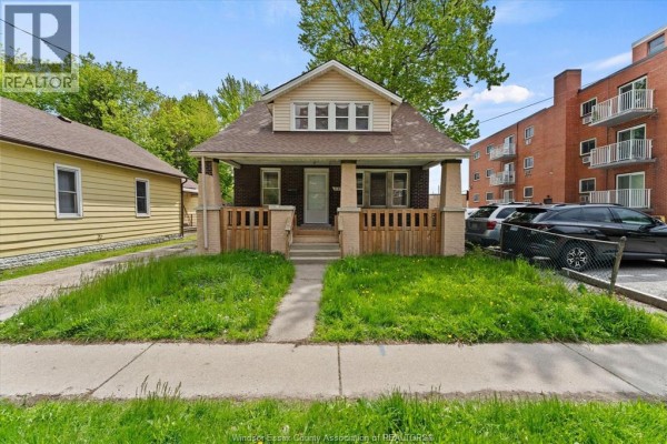 Street view of a brick house with a welcoming porch and green lawn in front. - 3185 Donnelly, Windsor