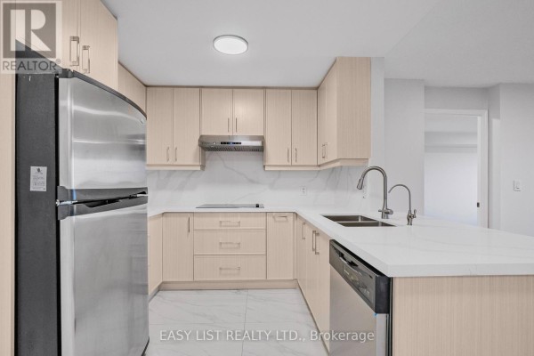 Modern kitchen with light wood cabinets, stainless steel appliances, and white countertops. - 319 - 2020 Mcnicoll Avenue, Toronto