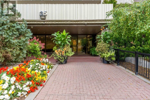 Entrance to the apartment building at 35 Ormskirk Avenue with planters and colorful flowers. - 319 - 35 Ormskirk Avenue, Toronto