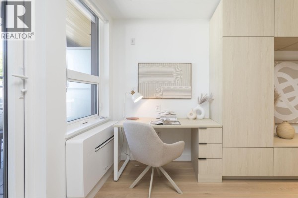Desk area with built-in cabinets and a window to the left of the desk. - 319 2471 St. George Street, Vancouver