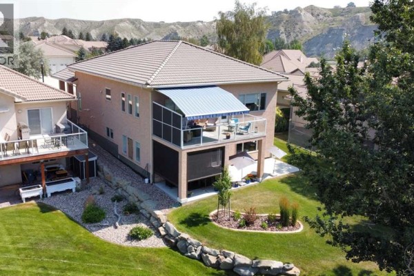 Aerial view of houses on a street with a river and coulees in the background. - 319 Canyon Boulevard W, Lethbridge