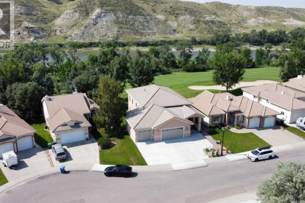 Aerial view of houses on a street with the Oldman River and coulees in the distance. - 319 Canyon Boulevard W, Lethbridge