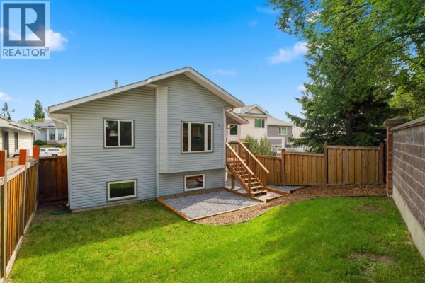 Finished basement with light grey carpet, beige walls, and two small windows overlooking a grassy area. - 319 Citadel Hills Place Nw, Calgary
