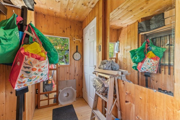 View of a sunroom with wood paneling, a door, windows, and various storage items. - 31a-31b Ch. Du Boisé, Val Des Monts