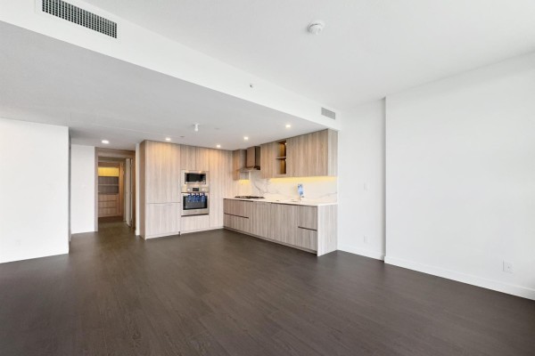 View of the living area and modern kitchen from across the room. - 31xx 13778 100 Avenue, Surrey
