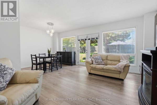 Living and dining area with beige couches, black dining set, and large windows. - 32 - 11 Livonia Place, Toronto