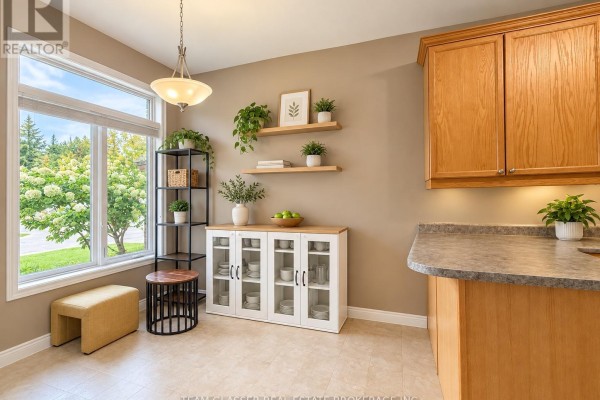 Dining area with a large window, plants, and a glass-front cabinet. - 32 - 44 Edgevalley Road, London East