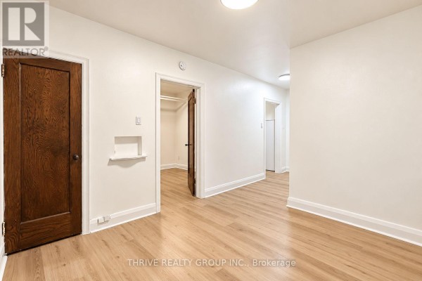 Interior living space with light wood floors, white walls, and dark wood doors. - 32 - 50 Ridout Street S, London South
