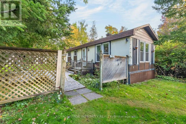 Exterior of a light-colored mobile home with brown trim and a wooden deck, viewed from the front. - 32 - 7481 Mitch Owens Road, Ottawa