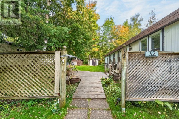 Wooden walkway leads to the entrance of the mobile home, flanked by lattice fences. - 32 - 7481 Mitch Owens Road, Ottawa
