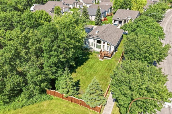 Aerial view of a house with a backyard surrounded by mature trees and wooden fencing. - 32 385 Willowlake Crescent, Winnipeg