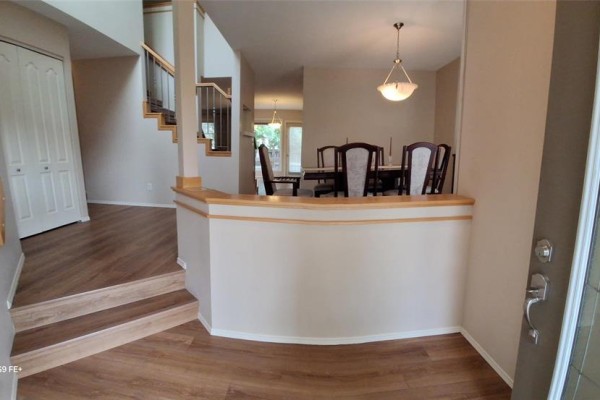 Interior entryway with double doors, bench, and wood-look flooring. - 32 495 Island Shore Boulevard, Winnipeg