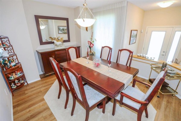Dining room with wood table, six chairs, buffet, and mirror. - 32 495 Island Shore Boulevard, Winnipeg