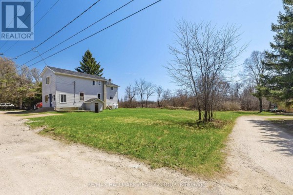 A large, open grassy field with a house visible in the distance and treed areas to the sides. - 32 Brock Street N, Perth