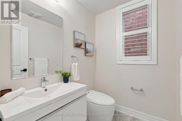Powder room with a white vanity, toilet, large mirror, and a window with blinds. - 32 Cyprus Glen, East Gwillimbury