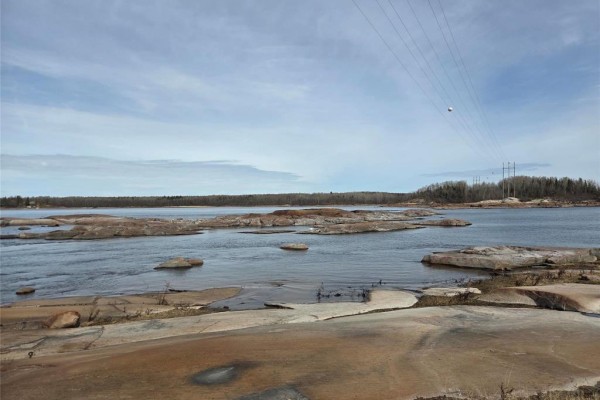 Aerial view of a wooded lot highlighted in yellow on a rocky, dark blue lake shore. - 32 Granite Point Road, Great Falls