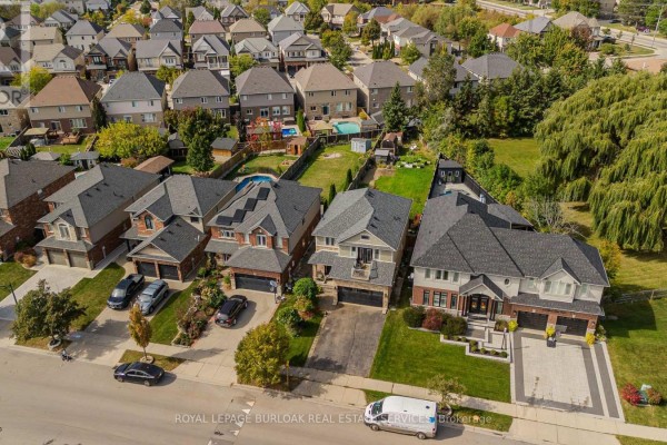 Aerial view of a suburban street with several two-story houses and manicured lawns. - 32 Great Oak Trail, Hamilton
