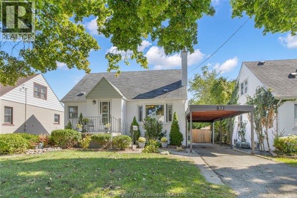 Daytime view of the white home with a grey roof, chimney, and mature trees in the front yard. - 32 Kerr Avenue, Chatham