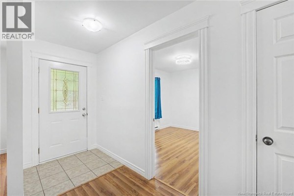 Interior entryway with a white door, beige floor tiles, and a view into a living area. - 32 Lena's Woods Lane, Geary