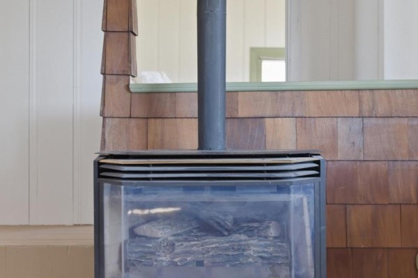 Wood-burning stove with wood paneling and stairs - 32 Quinte View Road Greater Napanee