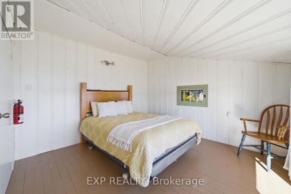 Bedroom with yellow bedding and a wooden chair - 32 Quinte View Road Greater Napanee