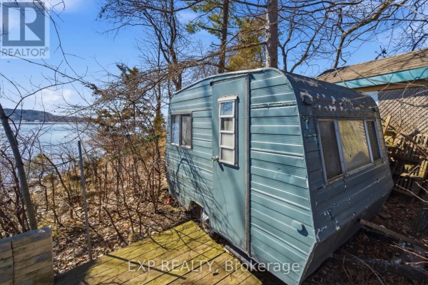 Blue trailer on wooden deck with water view - 32 Quinte View Road Greater Napanee