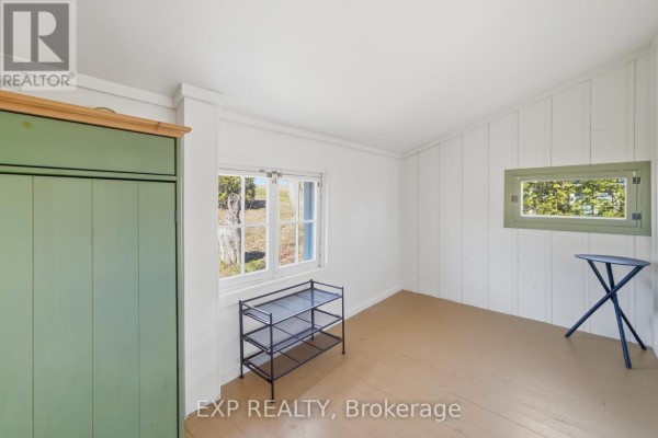 Green armoire and windows in a room with wood floors - 32 Quinte View Road Greater Napanee