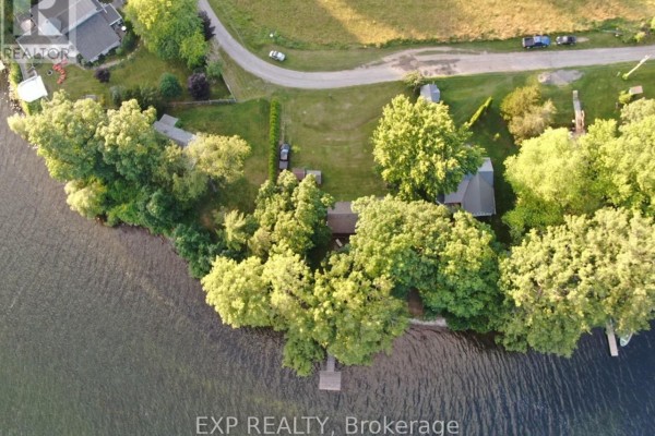 Aerial view of waterfront home with dock and treed lot - 32 Quinte View Road Greater Napanee