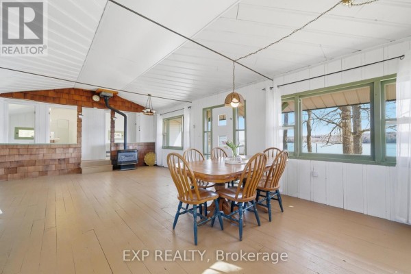 Dining room with wood stove and water view - 32 Quinte View Road Greater Napanee