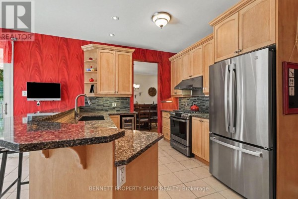Formal dining room with a large wooden table, chairs, buffet, fireplace, and hardwood floors. - 32 Rochelle Drive, Ottawa