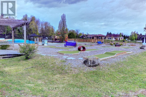 Outdoor mini-golf course with green turf, rocks, and colorful play structures. - 32 Temagami Trail, Wasaga Beach