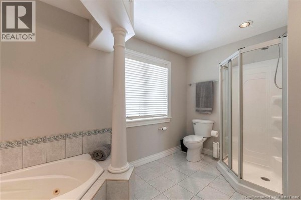 Master bathroom featuring a jetted tub, tiled surround, and window with blinds - 32 Vanessa Court, Riverview