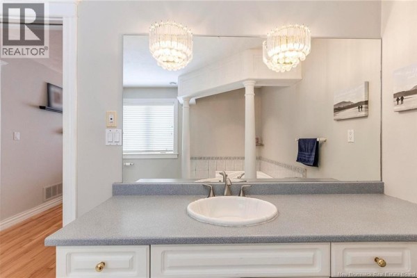 Close-up of glass shower enclosure in bathroom with white fixtures and gray towels - 32 Vanessa Court, Riverview