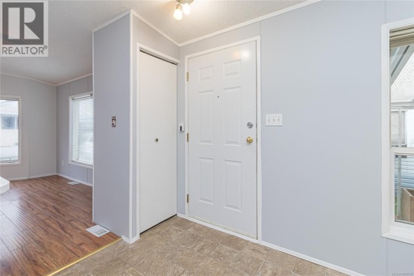 Entryway with front door, closet, and access to living area - 320 2885 Boys Rd, Duncan