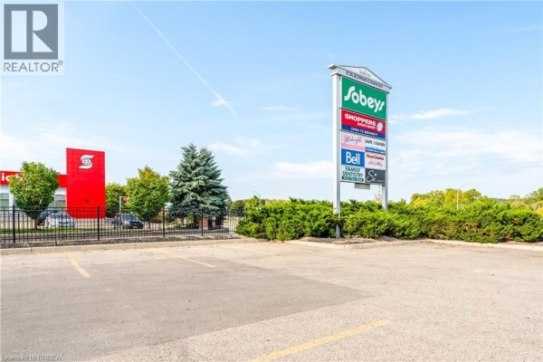 Signage for Sobeys and other businesses in the plaza, with landscaped area and parking lot. - 320 Colborne Street W Unit# 13, Brantford