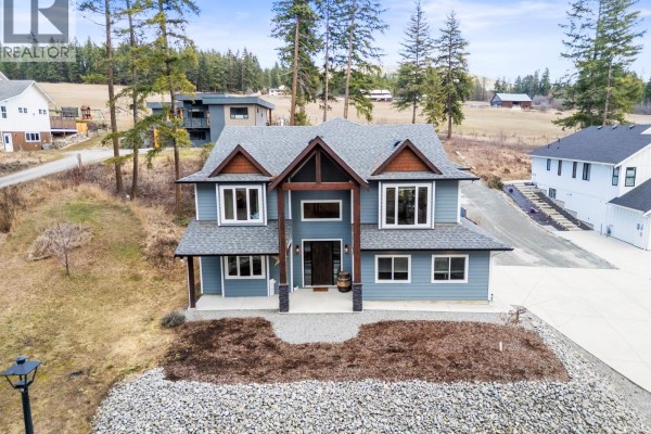 Aerial view highlighting the home's architecture and nearby properties. - 3200 20 Street Ne, Salmon Arm