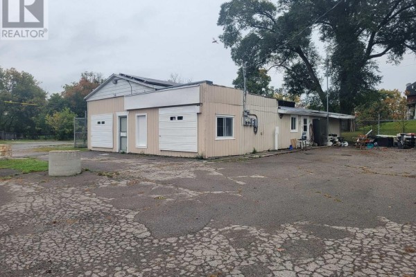 Side view of commercial building with multiple garage doors and windows. - 3201 County Road 41, Greater Napanee
