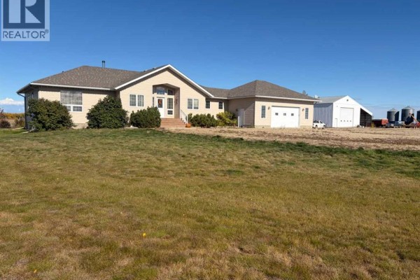 Front view of a beige ranch-style house with a green lawn and an attached garage. - 32048 Twp Rd 812, Rural Fairview No  136, M D  Of