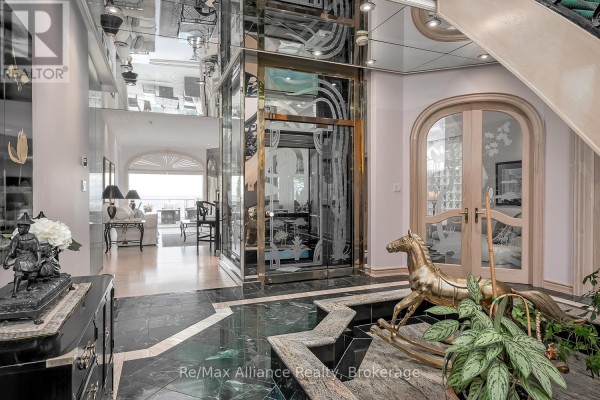 Interior view of the foyer with glass doors and decorative elements. - 3206 Shoreline Drive, Oakville