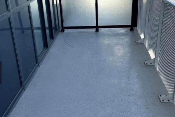 View of a small balcony with gray flooring and metal railing. - 3208 - 195 Commerce Street, Vaughan