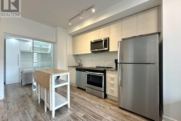 Kitchen area with stainless steel appliances, white cabinets, and island. - 321 - 621 Sheppard Avenue E, Toronto
