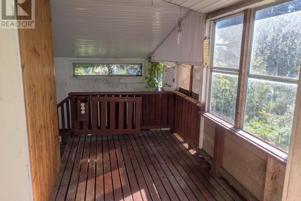 Interior view of a screened-in porch with wooden floorboards, railings, and large windows looking out to greenery. - 321 Mclean Avenue, Cornwall