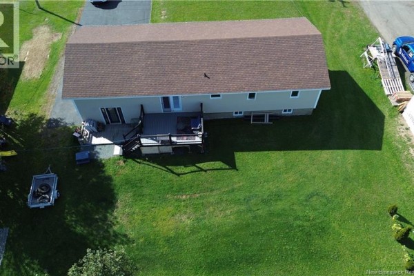 Aerial view of the rear of the bungalow with a wooden deck and backyard. - 321 Route 134, Petit Rocher Nord