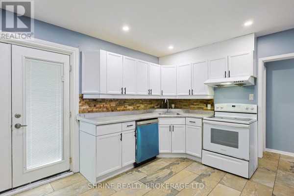 Kitchen with white cabinets, grey countertops, tiled backsplash, and tile flooring. - 321 Salisbury Street, London East