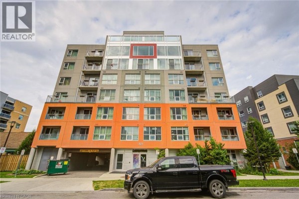 Front exterior of a multi-story apartment building with a red accent window on the upper floors. - 321 Spruce Street Unit# 710, Waterloo
