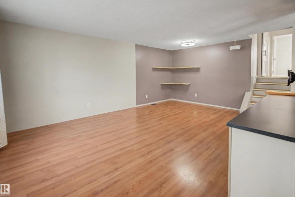 Kitchen with light wood cabinets, stainless steel appliances, and a breakfast bar. - 3211 71 St Nw, Edmonton