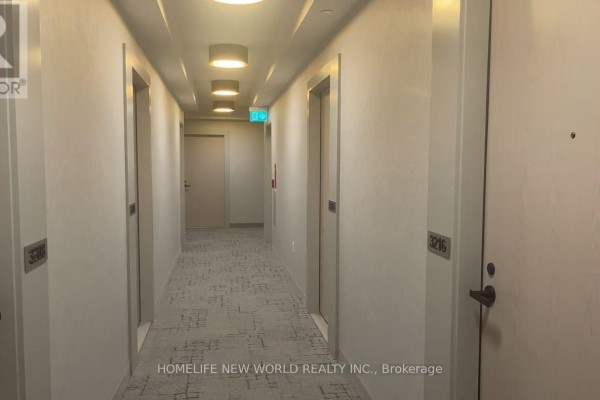 A long, modern apartment building hallway with multiple elevator doors and textured carpet. - 3212 - 28 Interchange Way, Vaughan